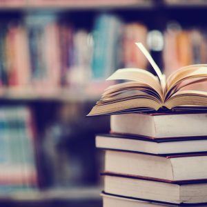 book-in-library-with-open-textbook-scaled.jpg